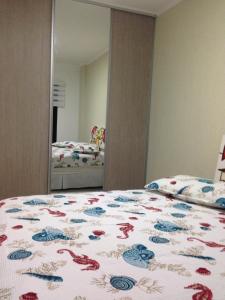 um quarto com uma cama e um espelho em Flat Guaruja Diferenciado no Guarujá