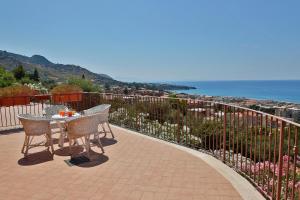 um pátio com uma mesa e cadeiras e o oceano em Terrazze Ponente e Levante - by Vacation Service em Cefalù