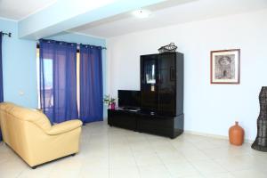 uma sala de estar com uma cadeira e um centro de entretenimento em Terrazze Ponente e Levante - by Vacation Service em Cefalù