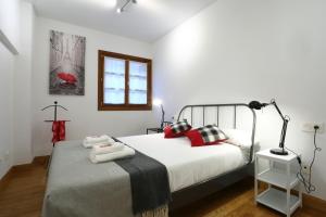 a bedroom with a bed with red and black pillows at Tolosa by Smiling Rentals in Hondarribia