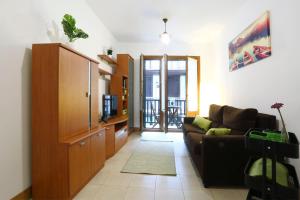 a living room with a couch and a tv at Tolosa by Smiling Rentals in Hondarribia