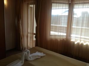 Una toalla blanca en una cama frente a una ventana en Snezhanka Apartments TMF, en Pamporovo 27 fotos más