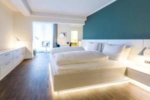 a bedroom with a white bed and white walls at Altera Hotel in Oldenburg