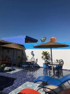un gruppo di tavoli e sedie con ombrelloni di Riad Salmiya Dune a Essaouira