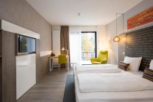 a hotel room with two beds and a desk at Landgoed ISVW in Leusden