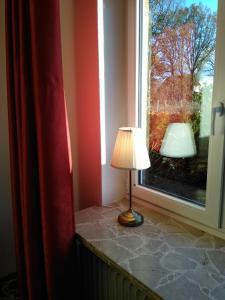 a lamp sitting on a window sill next to a window at Ferienwohnung Wisbek in Brinjahe +4 photos