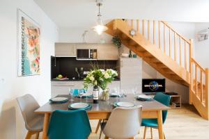 a dining room with a wooden table and chairs at Le 225 in Biscarrosse