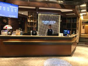 two men standing at a bar in a restaurant at James Joyce Coffetel Beijing Gulou street, Nanluoguxiang in Beijing