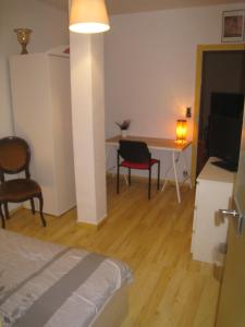 een slaapkamer met een bed, een bureau en een tafel bij Chambres Privatives Chez l'Habitant in Guebwiller