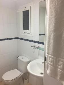 a white bathroom with a toilet and a sink at Hotel San Miguel in Altea