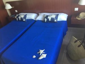 a blue bed with two pillows and starfish on it at Hotel San Miguel in Altea