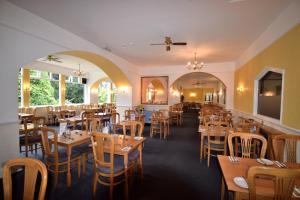 a dining room with wooden tables and chairs at Riviera Hotel in Torquay