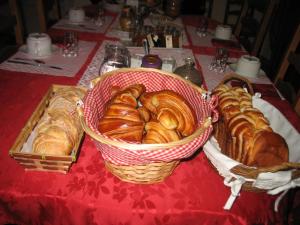 a table with baskets of croissants and pastries on it at La Maison d'Héloïse in Pruillé