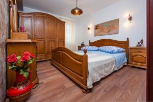 1 dormitorio con 1 cama y un jarrón con rosas rojas en Vista mare - Sea View, en Rovinj