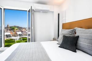 1 dormitorio con 1 cama y balcón con vistas. en iloftmalaga Ático Atarazanas, en Málaga