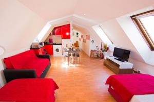 sala de estar con sofá rojo y TV en Apartamentos Madrid Centro en Madrid