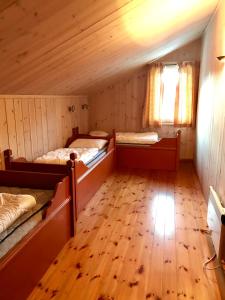 a room with two beds and a wooden floor at Kirkebøen Hytter in Hemsedal +45 photos