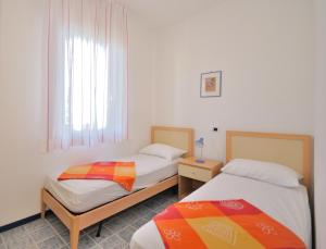 ビビオーネにあるCondominio Cormoranのベッド2台と窓が備わる客室です。