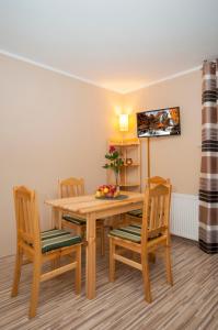 a dining room with a wooden table and chairs at Apartament Regina - Jantar in Kołobrzeg