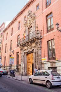 un coche blanco estacionado frente a un edificio en Apartamentos Madrid Centro en Madrid