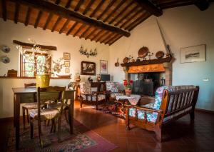 a living room with a table and chairs and a fireplace at Holiday Home Arpicella in Pienza