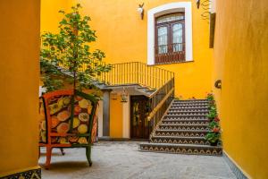 ein gelbes Gebäude mit einer Treppe und einem Stuhl in der Unterkunft Hotel Marqués del Ángel in Puebla