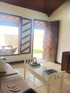 uma sala de estar com um sofá, uma mesa e uma porta em Casa das Fragatas - Cama e Café em Cabo Frio
