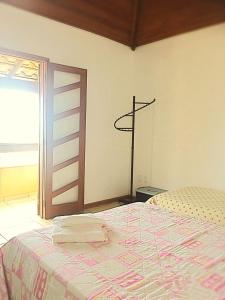 Un dormitorio con una cama en una habitación con ventana. en Casa das Fragatas - Cama e Café, en Cabo Frío