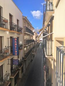 una calle vacía entre dos edificios con balcones en Ed l' alcudia en Benidorm