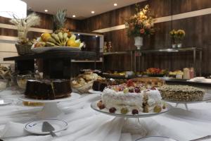 uma mesa com bolos e outras sobremesas em exposição em Hotel Blumenau - Balneário Camboriú em Balneário Camboriú