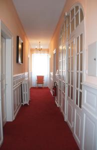 a hallway with a red carpet and a window at Villa Du Sendenbach in Muhlbach-sur-Munster