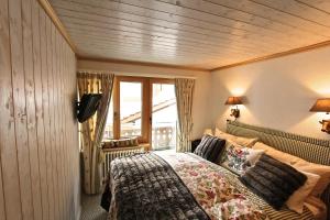 a bedroom with a bed and a large window at Chalet Drusa in Klosters Serneus