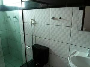een badkamer met een douche, een toilet en een wastafel bij Hotel Reobot in Garanhuns
