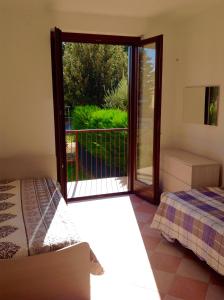 Pokój z łóżkiem i przesuwnymi szklanymi drzwiami w obiekcie Paola Apartments w mieście SantʼAmbrogio di Valpolicella