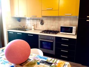 kuchnia z niebieskimi szafkami i stołem z różowym krzesłem w obiekcie Paola Apartments w mieście SantʼAmbrogio di Valpolicella