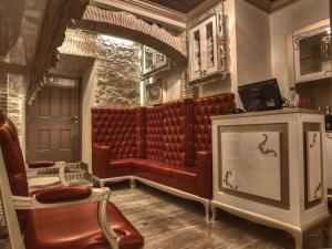 Una sala de espera con un sofá rojo y sillas. en Solar Antigo Luxury Coimbra, en Coímbra