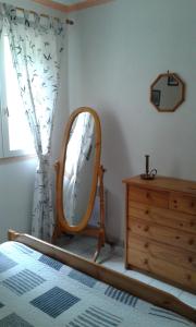 a bedroom with a mirror and a dresser and a window at Gite Sud de France-Carcassonne chez Léa in Aragon