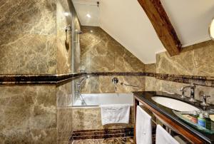 a bathroom with a tub and a sink at The Dominican in Prague