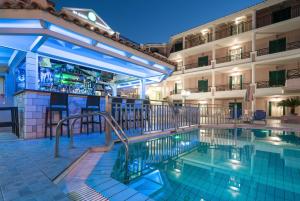 a swimming pool in front of a hotel at Alamis Hotel & Apartments in Tsilivi