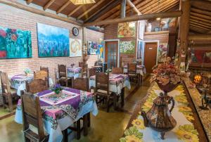 a restaurant with tables and chairs in a room at Pousada Alto da Neblina in Monte Verde