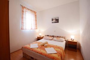 a bedroom with a bed with two towels on it at Apartments Ante in Omiš +201 photos