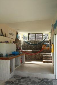 Habitación con una hamaca colgada de una pared de ladrillo. en Posada Rock-stone, en Providencia