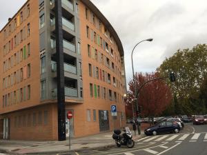 un edificio en una calle con una motocicleta estacionada al lado en SkyLinePamplona, en Pamplona