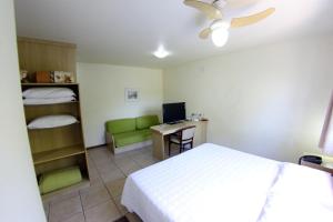 a bedroom with a bed and a desk with a computer at Hotel Antonio's in Santa Cruz do Sul