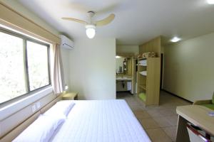 a bedroom with a white bed and a window at Hotel Antonio's in Santa Cruz do Sul