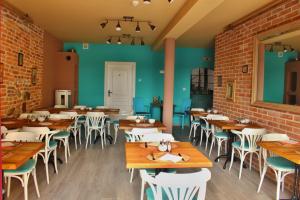 a restaurant with wooden tables and chairs and a brick wall at Penzion Kasper Cyklopenzion in Jindřichŭv Hradec