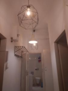 a bathroom with a toilet and a light hanging from the ceiling at Central Warsaw Apartment in Warsaw