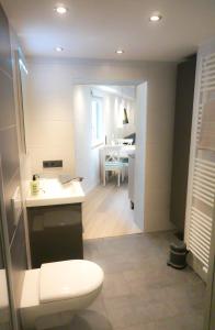 ein Bad mit einem WC, einem Waschbecken und einem Tisch in der Unterkunft Ferienwohnung Saalhausen Sauerland in Saalhausen