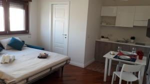 フォッジャにあるCasa Rosatiのベッド、テーブル、キッチンが備わる客室です。