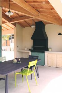 a kitchen with a dining table and yellow chairs at Le 27 in Malaucène